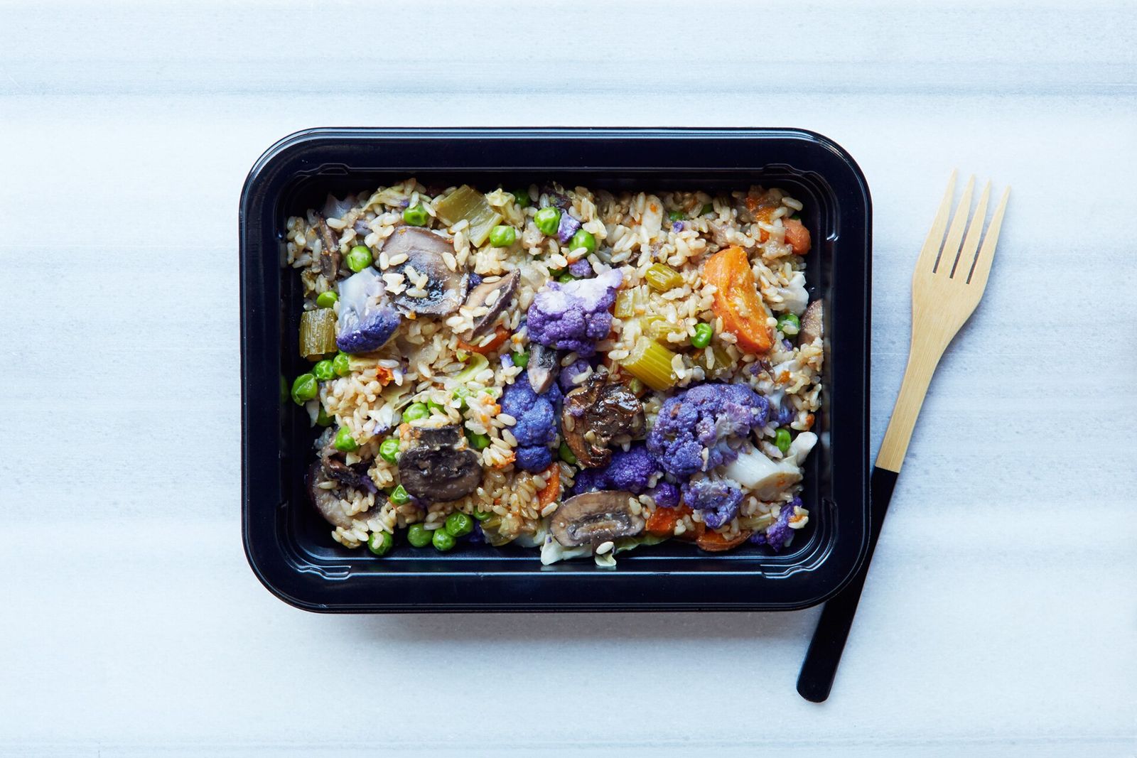 An overhead view of a meal-prep container filled with rice and vegetables