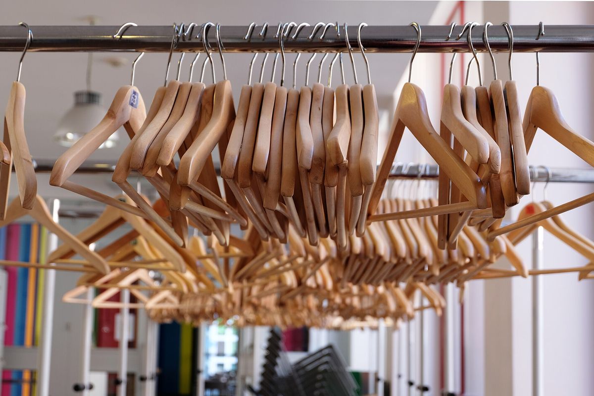 Matching wooden hangers on a clothes rail