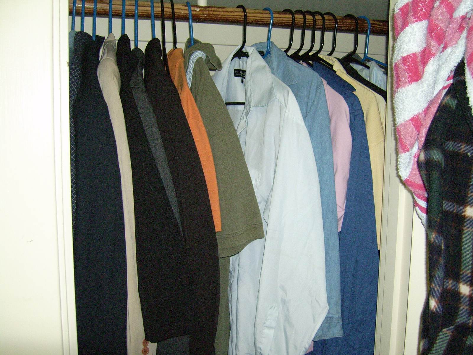 Clothes hanging on a rail inside a closet